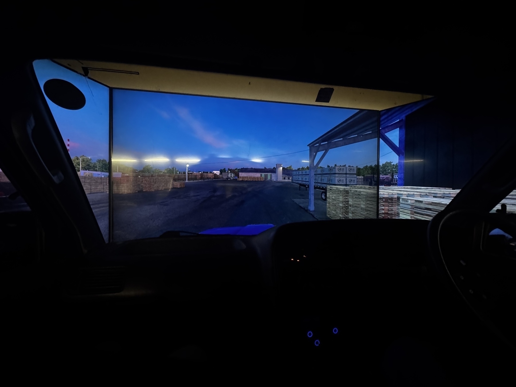 A dark photo from inside of the front seat of a HiAce van showing the three monitors that surround it to turn it into a simulator.